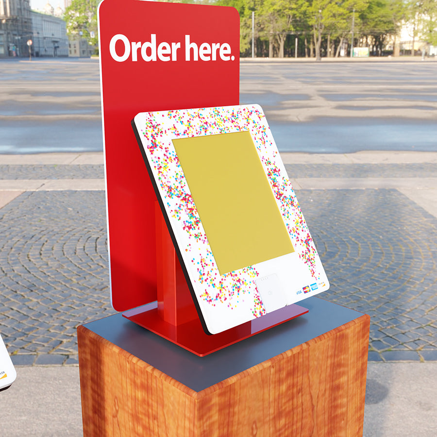 A countertop kiosk with a card reader and custom backdrop.